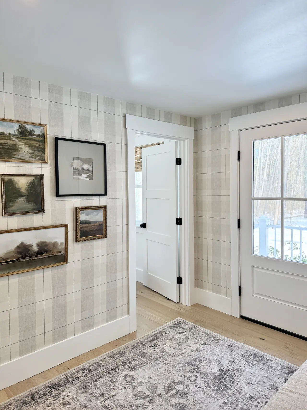 A gallery-wall hallway with framed art and paneled doors