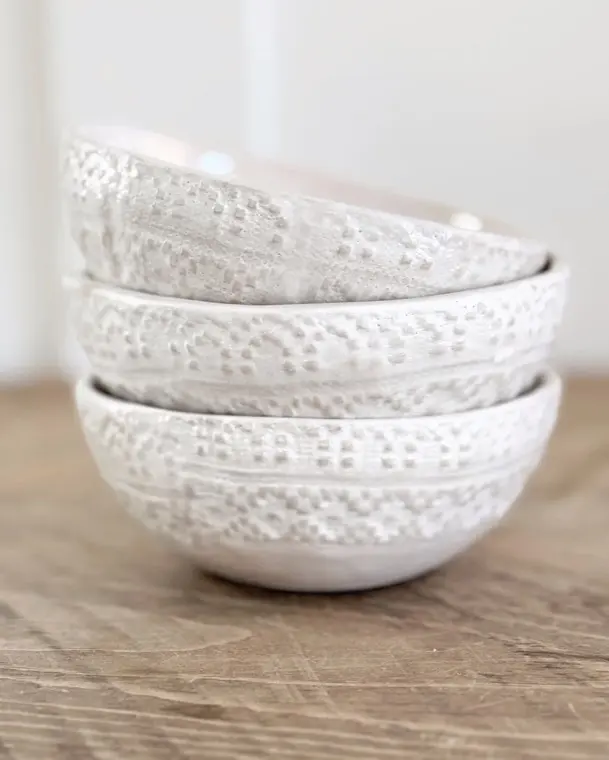 A stack of hand-glazed textured ceramic bowls
