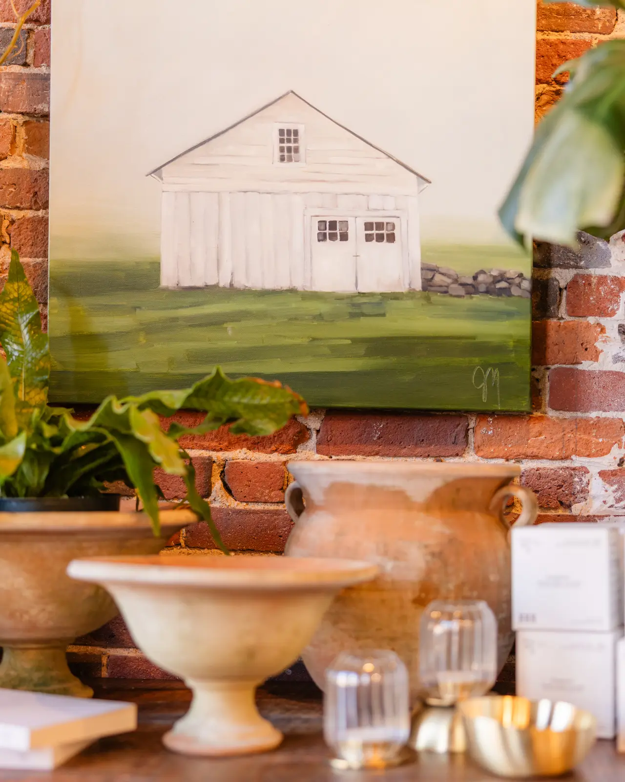 A barn painting above a vignette of vessels
