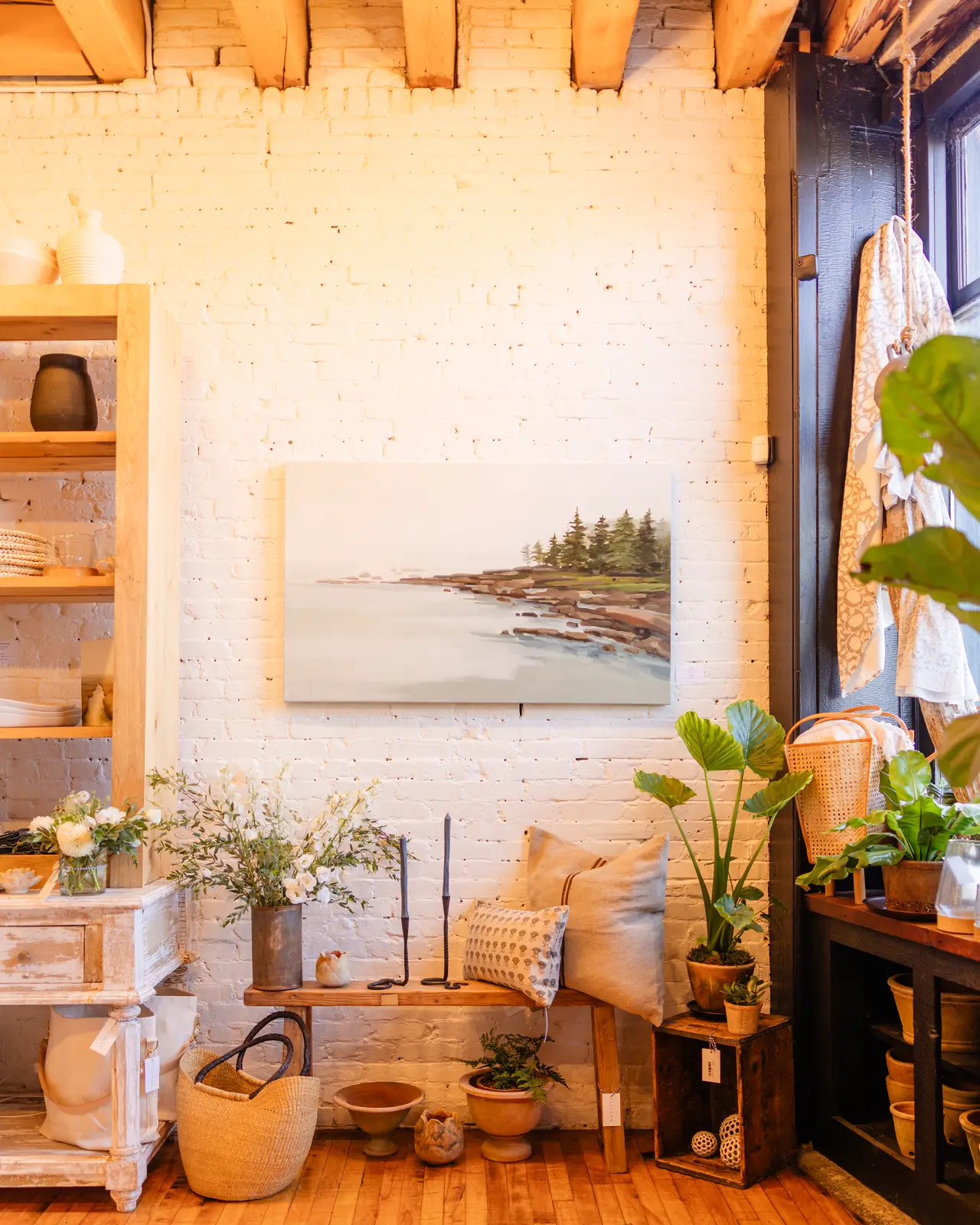 A coastal painting on the brick wall with plants