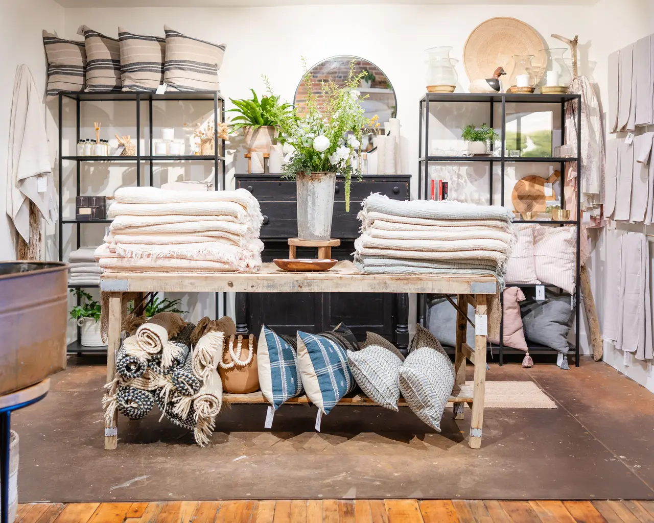 A table of folded throws and textiles
