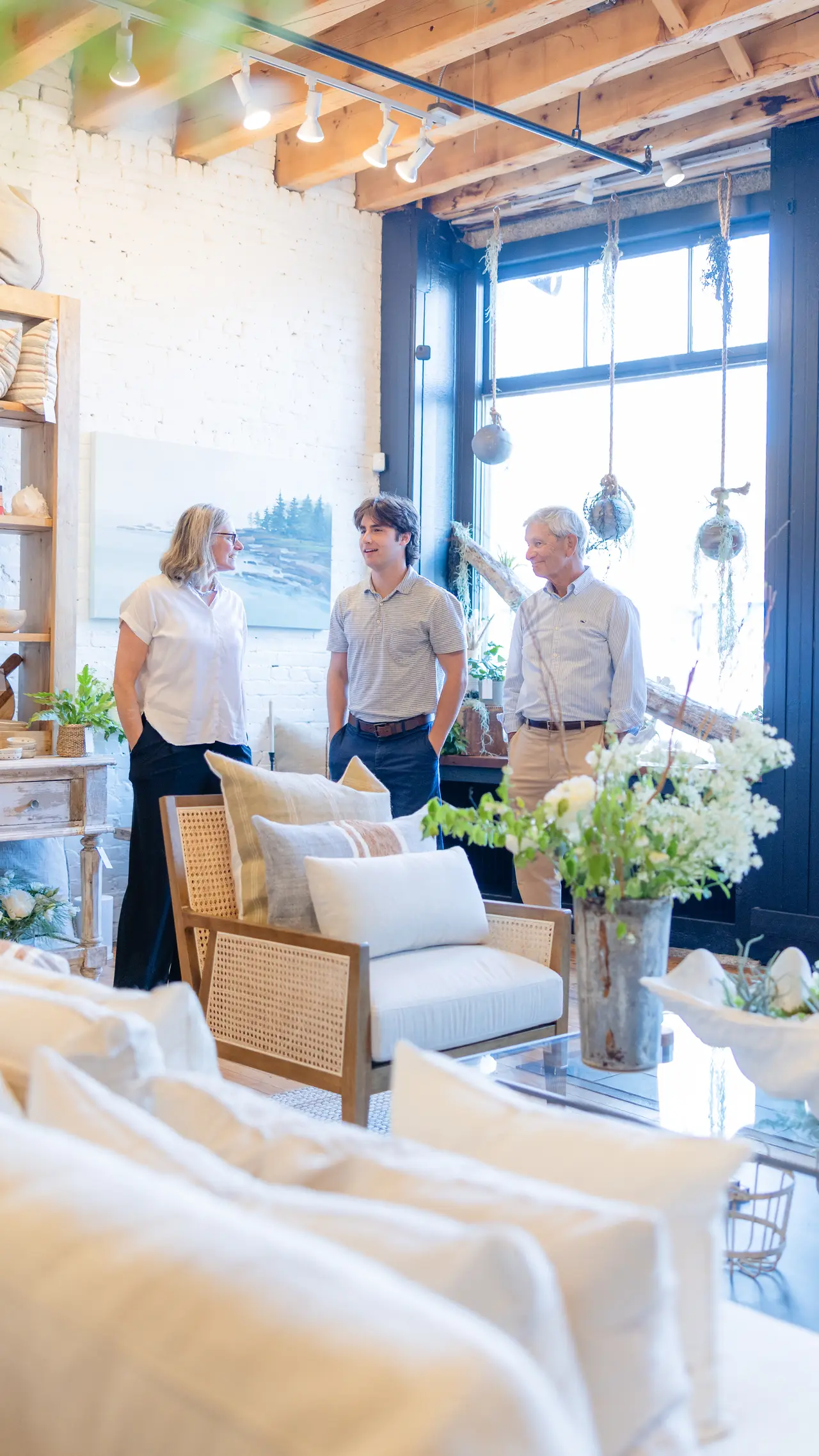 Guests gathering by the linen sofas at the Portland opening