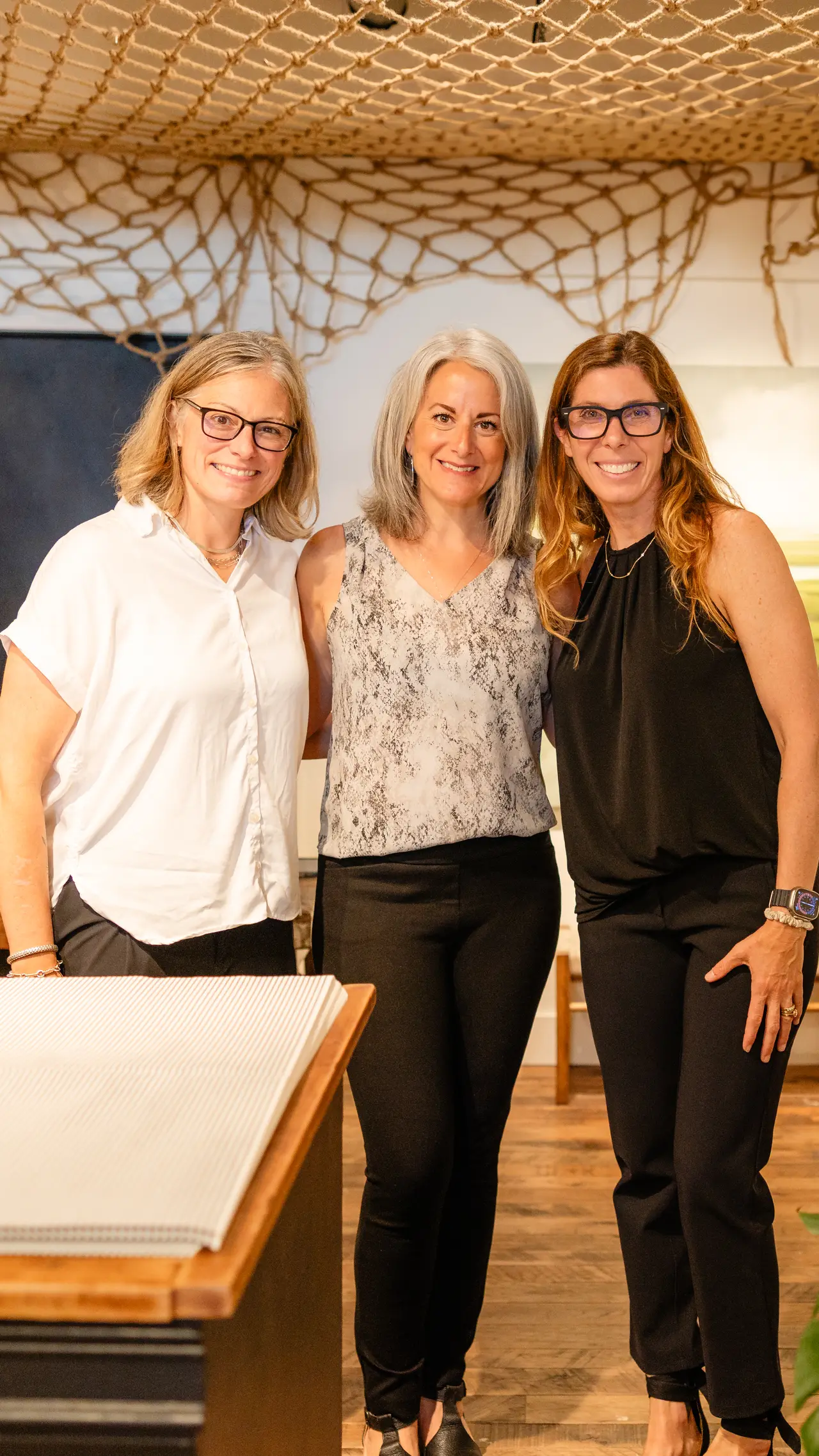 Three friends together under the fishing-net ceiling